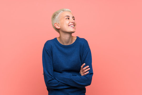 Teenager girl with white short hair over pink wall happy and smiling