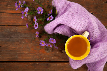 Autumn still life with cup of tea, plaid and leaves on wooden background