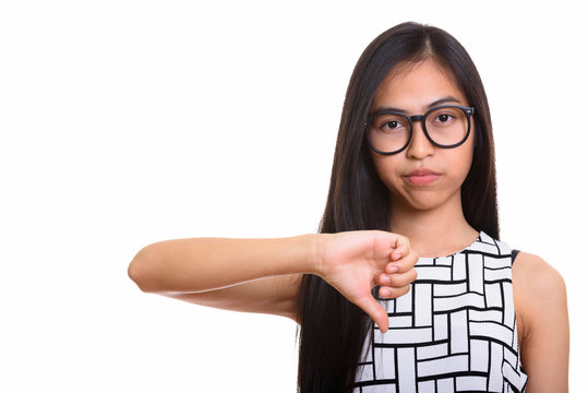 Young Asian teenage nerd girl giving thumb down