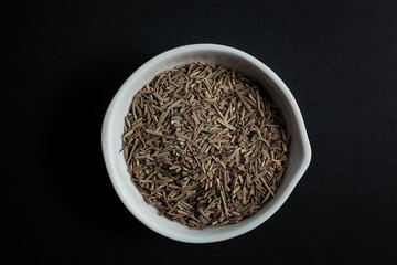 Fototapeta na wymiar Spice cumin in a white ceramic bowl isolated on black background