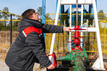 Oil, gas industry. The man controls the process of the oil pump close-up. A man near the oil pump.