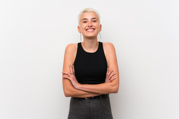 Teenager girl with short hair over white wall keeping the arms crossed in frontal position