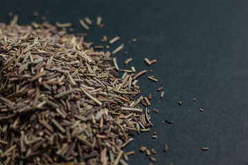 Spice caraway seeds sprinkled on a black background