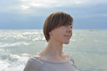 Close-up portrait of a short-haired woman at the sea