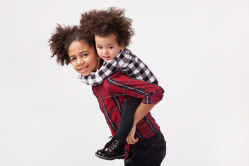 Teenage girl giving her little sister a piggyback ride