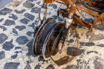 Burned motorcycle on the street detail of the front wheel