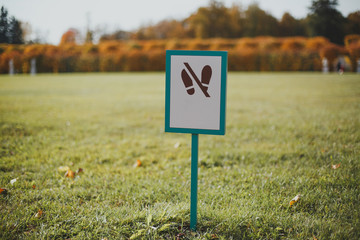 Warning sign - Do not walk the lawn on a sunny autumn lawn in a park 1