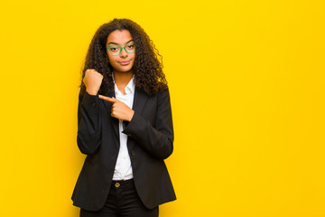 black business woman looking impatient and angry, pointing at watch, asking for punctuality, wants...