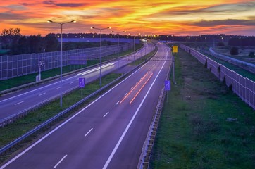 Highway at night. Beautiful colorful sky with the setting light over the A1 highway in Poland.