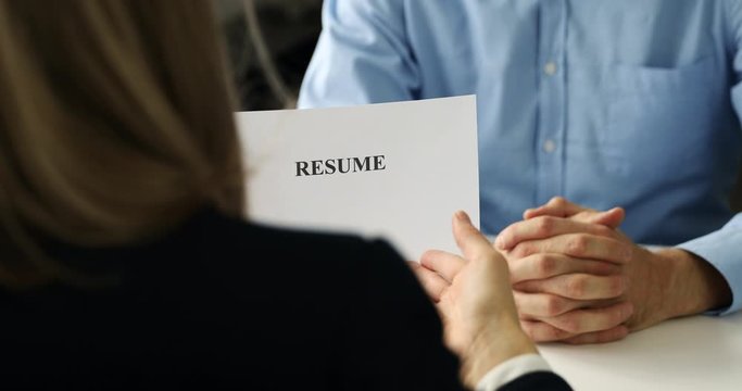 job interview - hiring manager and candidate discussing resume in office