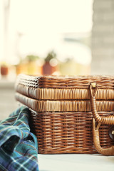 Obraz premium Close up of a wooden basket with dishware on white table