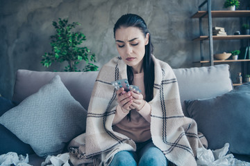 Photo of exhausted lady feeling bad choosing suitable pills from flu covered with blanket wearing...