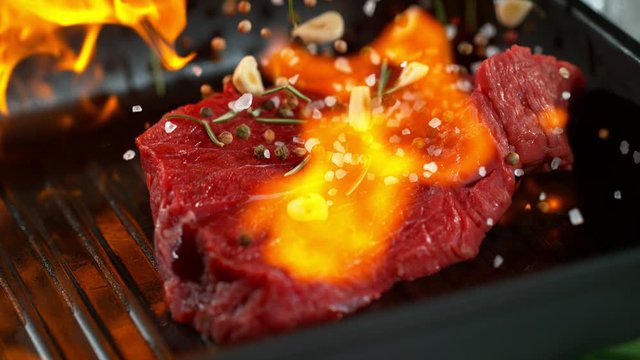 Super slow motion of falling beef steak into flames. Filmed on high speed cinema camera, 1000 fps.