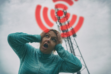 Woman is holding her head near the 5G BTS