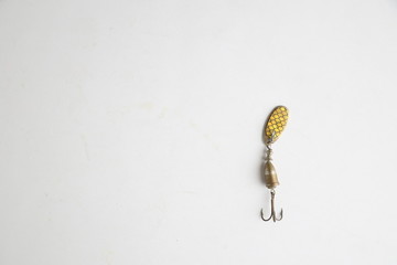 Teaspoon-shaped fishing lure on color background