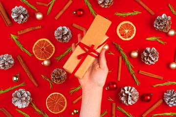 Woman hand with gift on decorated christmas background