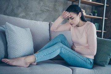 Profile photo of pretty lady suffering from period holding hands on hurted belly and forehead...