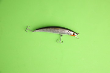 fish-shaped fishing lure on color background