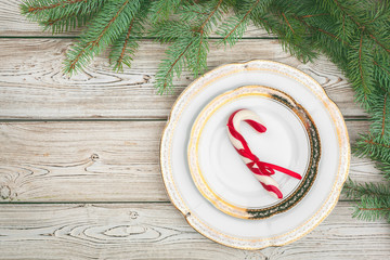 Wooden table with pine tree branches and holiday table setting