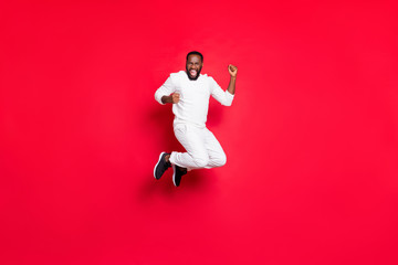 Full length photo of excited dark skin handsome guy jumping high rejoicing at best x-mas party...