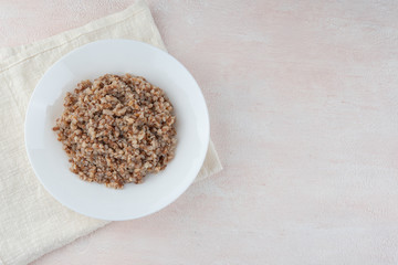 Buckwheat porridge on a white plate, light background.