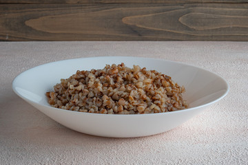 Buckwheat porridge on a white plate, light background.