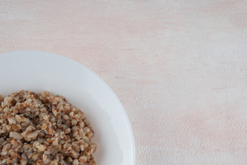 Buckwheat porridge on a white plate, light background.