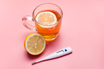 Tea with lemon, ginger and honey on a pink background. Treatment of colds and flu.