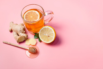 Tea with lemon, ginger and honey on a pink background. Treatment of colds and flu.