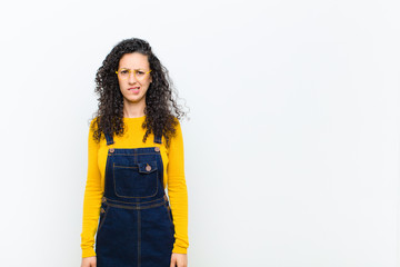 young pretty woman feeling clueless, confused and uncertain about which option to pick, trying to...