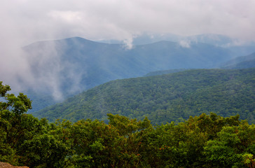 Fototapeta premium View of fog and mountains from the summit of Spy Rock, a popular hiking destination near the Appalachian Trail in the Blue Ridge mountains near Montebello, Virginia