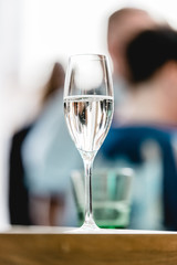 Glass with champagne lit by nightclub lights