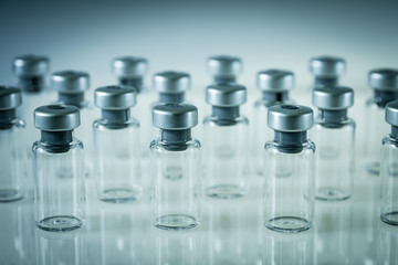 Vaccine glass bottles on grey background