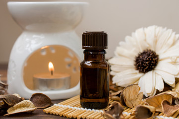 Aroma lamp with hot candles, a bottle of oil and a flower, decor in beige colors. Aromatherapy, relaxing atmosphere