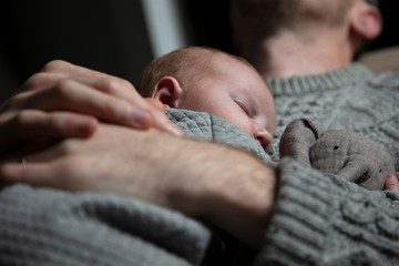 A father holding his baby son on his chest. Family bonding. Fatherhood