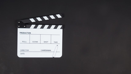 Fototapeta na wymiar Clapperboard or clap board or movie slate with pen use in video production ,film, cinema industry.Put on black background.