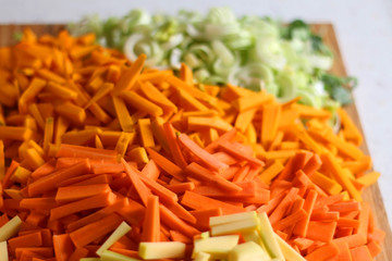 Chopped leek, pumpkin, carrot and zucchini on a cutting board. Selective focus, close-up.