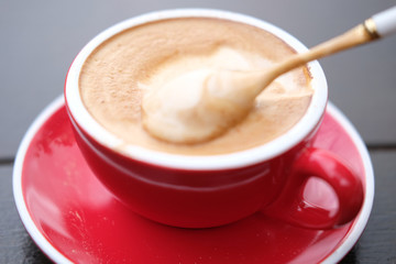 cup of coffee with cream on wooden background