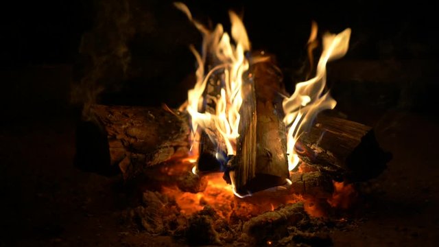 Flames of a campfire in the night. Fire burning in fireplace. Slow motion shot