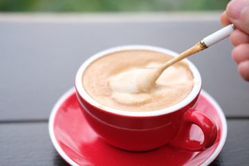 cup of coffee with cream on wooden background