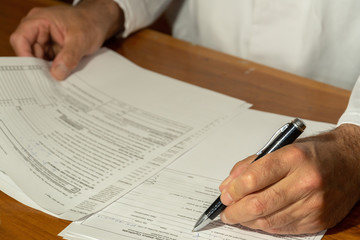 Cropped image of a man filling in a form, documents or paperworks