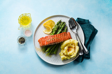 grilled salmon with fresh asparagus and mashed potatoes on a plate. healthy food on the table