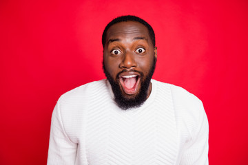 Close up photo of amazed surprised dark skin man hear wonderful incredible news about xmas discounts scream wow omg wear white pullover isolated over red color background