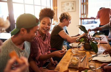Smiling group of diverse friends talking over lunch together
