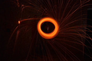 Long exposure image of steel wool photography, light painting in the night at the dark room. Soft focus due to long exposure