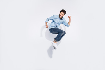 Full body profile photo of funny arabian guy jumping high rejoicing of great win raising fists wear...