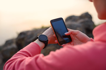 Woman Runner Syncing Fitness Data between the Smartwatch and Smartphone after Workout. Sports and...