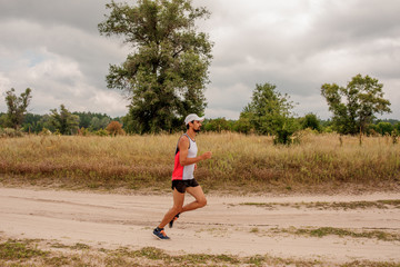 Man running outdoors with a beard in a sports uniform in nature, day, open air