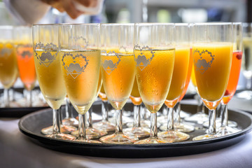 sparkling wine in glasses with orange juice in restaurant or wedding party dinner setting