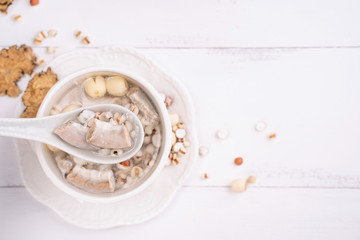 Tasty Four Tonics Herb Flavor Soup, Taiwanese traditional food with herbs, pork intestines on white wooden table, close up, flat lay, top view